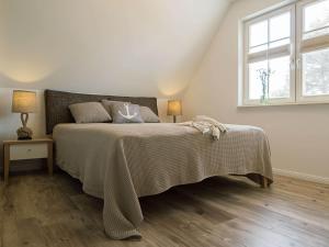 a bedroom with a bed with a blanket and a window at Ferienhaus "Zum Achterknoten" in Zingst