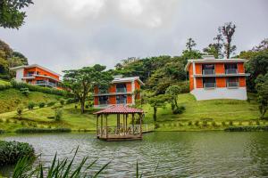 a house on a hill next to a body of water at Burbi Lake Lodge Monteverde in Monteverde Costa Rica