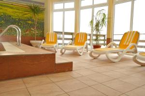 ein Wartezimmer mit gelben Stühlen und einer Badewanne in der Unterkunft FerienDüne 1 in Kägsdorf