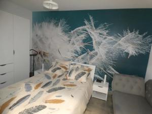 um quarto com uma cama com penas na parede em gite de la libellule em Commentry