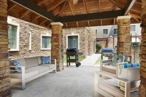 a patio with two couches and a grill at Staybridge Suites Of Durham - Chapel Hill - RTP by IHG in Durham