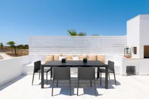 a black dining room table and chairs on a balcony at Seacarf Villa, 3 magnificent properties in Lachania beach, Bedrooms 12, Sleeps 27 in Lachania