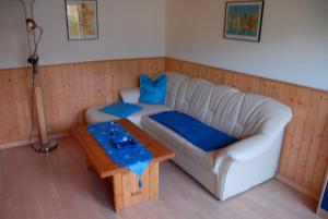 - un salon avec un canapé blanc et une table dans l'établissement Ferienwohnung Cantay - Nr1, à Fehmarn