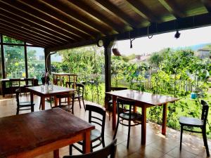 ポオ・デ・リャネスにあるEco-Hostel La Casa Verdeのテーブルと椅子、大きな窓のあるレストラン