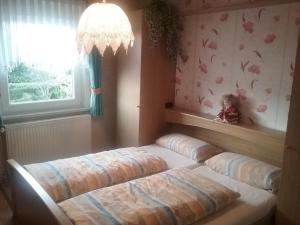 two beds in a room with a window at Komfort 4 Sterne Wohnung " Flut " für 4 Erw Kleinkind in Ostfriesland in Utarp