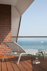 a chair on a balcony with a view of the ocean at Albatros in Haffkrug