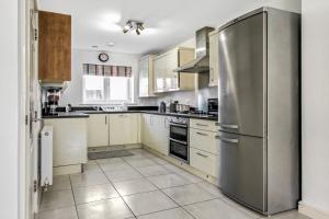 a kitchen with a stainless steel refrigerator and white cabinets at Emerald En-suite in Derby in Derby