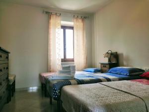 PreciにあるIl Fiordalisoのベッド3台と窓が備わる客室です。