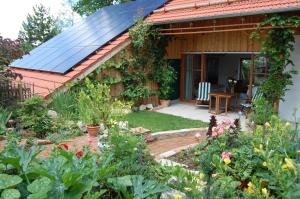 a garden with a house with a solar roof at Studio Via Claudia Augusta in Denklingen