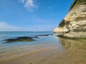 a beach with rocks and the ocean on a sunny day at Le calme de la nature à 8 minutes des plages in Sémussac