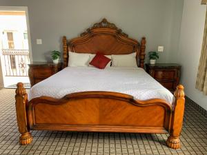a bed with a white bedspread and a wooden headboard at Viking Motel-Ventura in Ventura