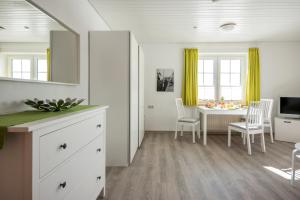 eine Küche und ein Esszimmer mit einem Tisch und Stühlen in der Unterkunft Knusthof Lafrenz - Küstenblick in Fehmarn