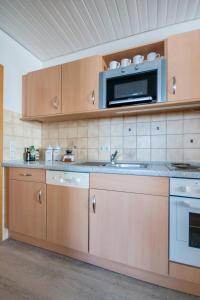 eine Küche mit einer Spüle und einer Mikrowelle in der Unterkunft Knusthof Lafrenz - Küstenblick in Fehmarn