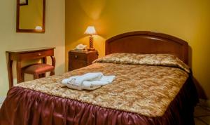 a hotel room with a bed with two towels on it at HOSTAL MONUMENTAL a Media Cuadra de la Plaza Mayor in Cajamarca