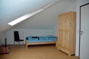 a bedroom with a bed and a chair in a attic at Feriendomizil Bellevue in Walchum