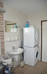 a bathroom with a sink and a washing machine at Feriendomizil Bellevue in Walchum