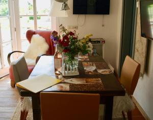 a dining room table with flowers on top of it at Die alte Kate in Tribohm