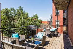 a patio with chairs and a grill on a building at MTLVacationRentals -The Chic Laurier in Montreal