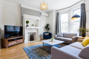 un soggiorno con un divano e una TV di MTLVacationRentals -The Chic Laurier a Montréal