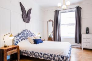 Un dormitorio con una cama azul y blanca y una ventana en MTLVacationRentals -The Chic Laurier, en Montreal