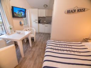 ein Schlafzimmer mit einem Bett und einem Tisch sowie eine Küche in der Unterkunft Welle 39a in Scharbeutz
