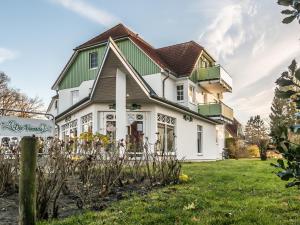 a white house with a green roof at Hafenstraße 38 Whg 5 in Zingst