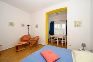 een slaapkamer met een blauw bed en een tafel en stoelen bij Villa Christiana - Stranddistel in Graal-Müritz