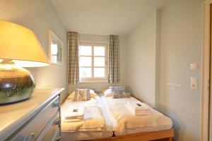 a bedroom with a bed with a lamp and a window at Bornholm Whg2 in Nieblum