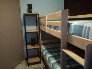 Charmant Lodge tout confort في Matoury: غرفة بسريرين بطابقين ومرآة