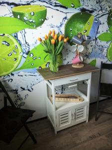 - une table avec un vase de fleurs à côté d'un lit dans l'établissement Ferienwohnung Margot in VS, à Villingen-Schwenningen