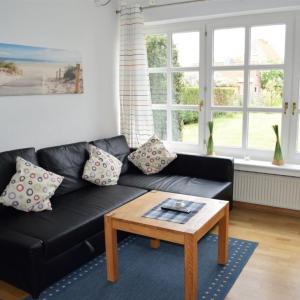 a black leather couch in a living room with a coffee table at Finke-Ferienhaus - EG in Grömitz