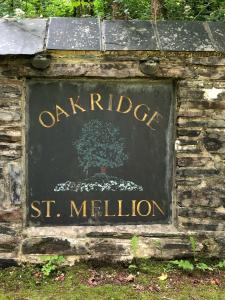 Un signo de campo de materias primas en una pared de piedra en The Nineteenth, Oakridge St Mellion, Free Golf/SPA, en St Mellion