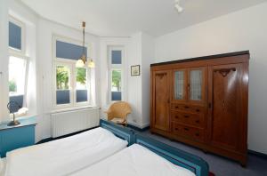 ヴィーク・アウフ・フェールにあるHaus Poggfred Whg 04 Harmensのベッドルーム1室(ベッド1台、ドレッサー、窓付)