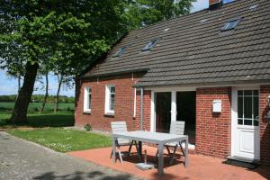 a picnic table in front of a brick house at Haus Linden in Hage