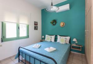 a blue bedroom with a bed with a blue wall at Chania Sea View Summer House in Kalamaki Chanion