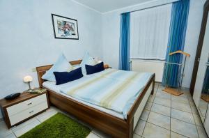 a bedroom with a large bed with blue curtains at Ferienwohnung Leitges in Bettenfeld