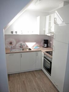 a kitchen with white cabinets and a sink at "Landhaus Voss" Typ 4 Nr12 in Staberdorf