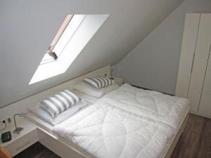 a bedroom with a bed with a skylight at "Landhaus Voss" Typ 4 Nr12 in Staberdorf