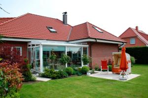 a house with a red roof and a patio at Privatzimmer Ehrhardt Nr1 in Burg auf Fehmarn
