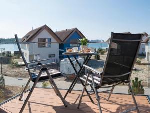 ハイリゲンハーフェンにあるOstsee - Appartement Nr 182 "Sunshine Oase" im Strand Resortのテーブルと椅子2脚、バルコニー(テーブル付)