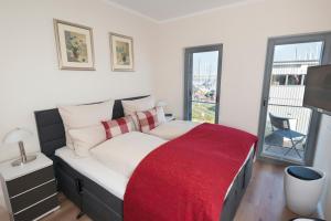 ハイリゲンハーフェンにあるOstsee - Appartement Nr 182 "Sunshine Oase" im Strand Resortのベッドルーム1室(赤い毛布付きのベッド1台付)