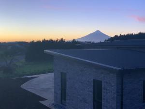 een uitzicht op een gebouw met een berg op de achtergrond bij Executive-style home away from home. in Hawera