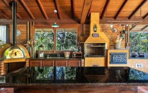 eine Küche mit einem Herd und einer Arbeitsplatte in der Unterkunft Casa Serrana, 4 quartos com ar e piscina aquecida em meio à Natureza de Itaipava in Itaipava