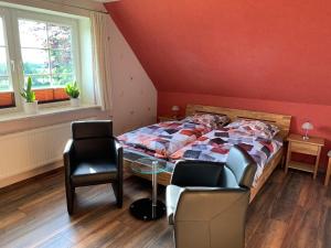 1 dormitorio con 1 cama, mesa y sillas en Wittensee-Blick, en Neu Duvenstedt
