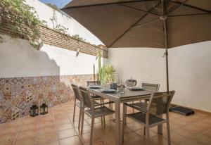 una mesa con sillas y una sombrilla en el patio en Beautiful townhouse beachfront en Marbella