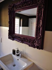 a bathroom with a sink and a mirror on the wall at BLUMENSTIL Ferienwohnungen 3 in Bad Salzungen