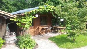 ein Holzhaus mit einem Tisch und einer Pergola in der Unterkunft Studio Summer Garden in Trassem