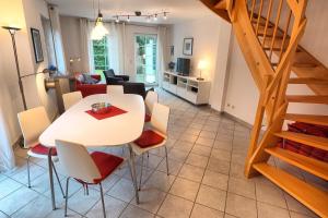 uma sala de jantar e sala de estar com mesa e cadeiras em Strandbiene em Zingst