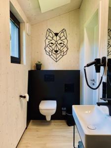a bathroom with a toilet and a black wall at Naturlodges Edersee - Lodge #2 in Hemfurth-Edersee