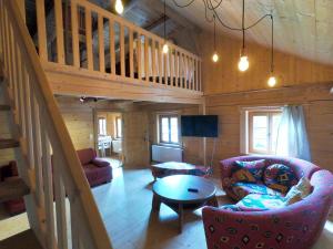 a living room with a staircase in a log cabin at Biohof Neihausmo in Böbing